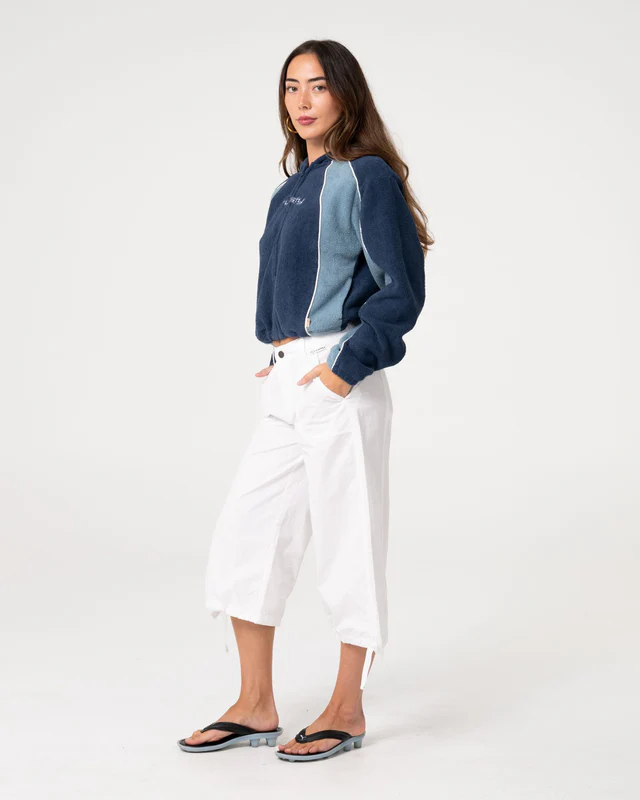 Το Two Tides Cropped Zip Through Polar Fleece είναι ένα cropped φούτερ με κουκούλα και φερμουάρ σε όλο το μήκος, σχεδιασμένο για άνεση και μοντέρνο athleisure στυλ.