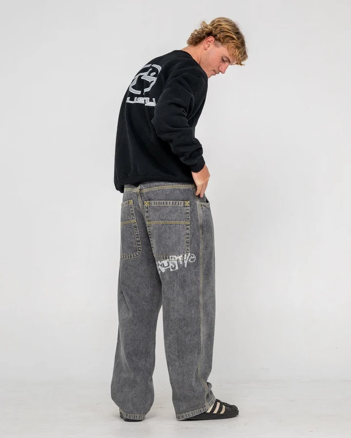 Rusty – Redemption Baggy Jean Το Rusty Redemption Baggy Jean διαθέτει baggy εφαρμογή με χαλαρή, oversized γραμμή για έντονο streetwear χαρακτήρα. Κατασκευάζεται από 100% cotton indigo denim και διαθέτει contrast ραφές, oversized τσέπες και χαρακτηριστικό Rusty Ransom screen print.
