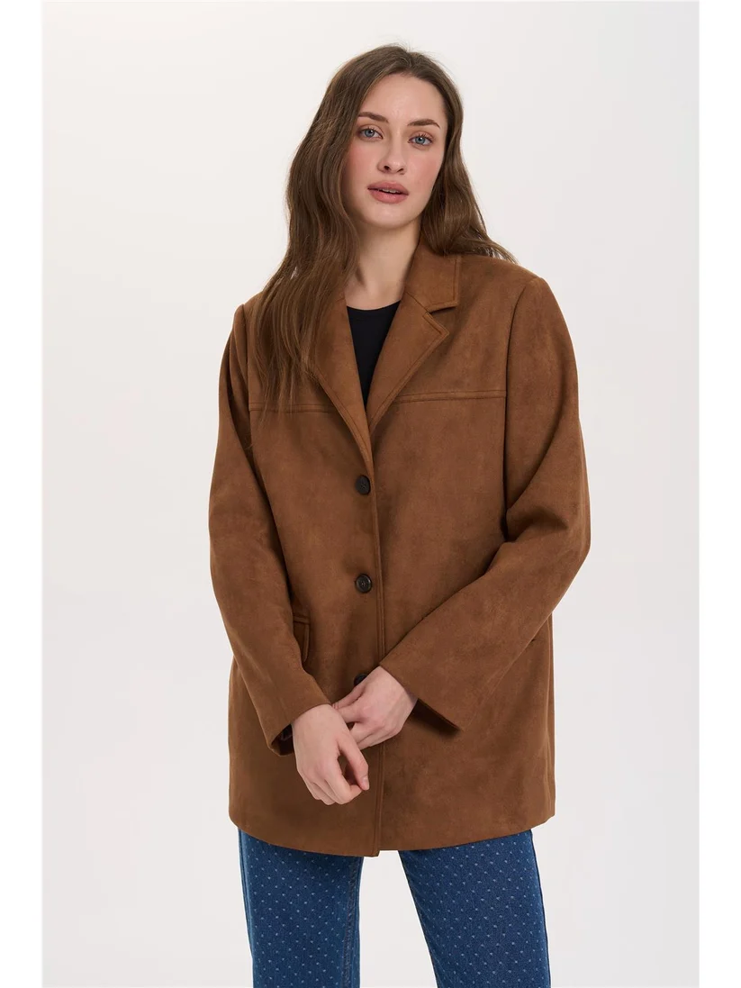 Κομψό blazer από vegan suede της 24COLOURS, σε ίσια και άνετη γραμμή. Διαθέτει κλασικό γιακά με πέτο, κλείσιμο με τρία κουμπιά και δύο μπροστινές τσέπες με καπάκι. Οι διακριτικές ραφές ολοκληρώνουν τον λιτό και διαχρονικό σχεδιασμό.
