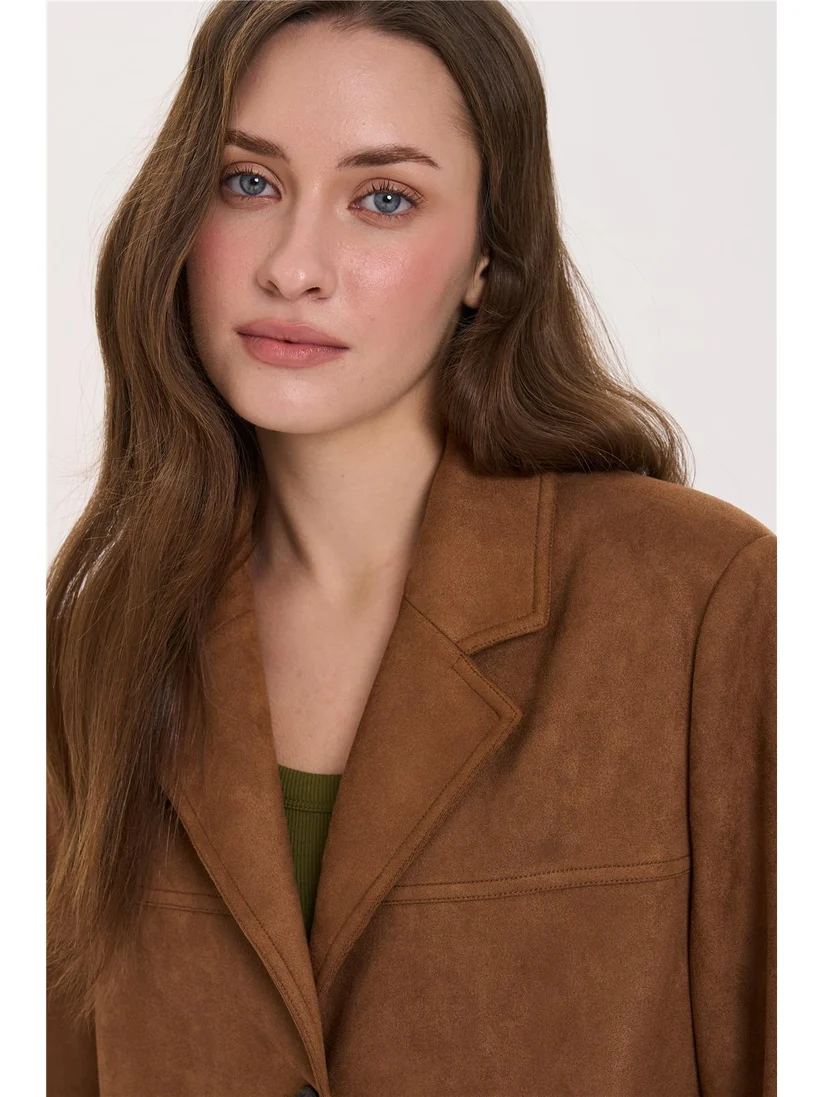 Κομψό blazer από vegan suede της 24COLOURS, σε ίσια και άνετη γραμμή. Διαθέτει κλασικό γιακά με πέτο, κλείσιμο με τρία κουμπιά και δύο μπροστινές τσέπες με καπάκι. Οι διακριτικές ραφές ολοκληρώνουν τον λιτό και διαχρονικό σχεδιασμό.