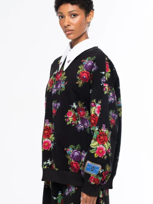 Το Bouquet Sweater συνδυάζει τη relaxed αισθητική ενός sweatshirt με θηλυκές, ιδιαίτερες λεπτομέρειες. Οι διακριτικές bishop sleeves και το εντυπωσιακό all-over print με ψηφιακά σχεδιασμένα λουλούδια εμπνευσμένα από την τεχνική του cross stitch χαρίζουν στο κομμάτι ξεχωριστό χαρακτήρα.