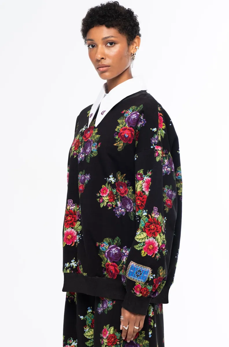 Το Bouquet Sweater συνδυάζει τη relaxed αισθητική ενός sweatshirt με θηλυκές, ιδιαίτερες λεπτομέρειες. Οι διακριτικές bishop sleeves και το εντυπωσιακό all-over print με ψηφιακά σχεδιασμένα λουλούδια εμπνευσμένα από την τεχνική του cross stitch χαρίζουν στο κομμάτι ξεχωριστό χαρακτήρα.