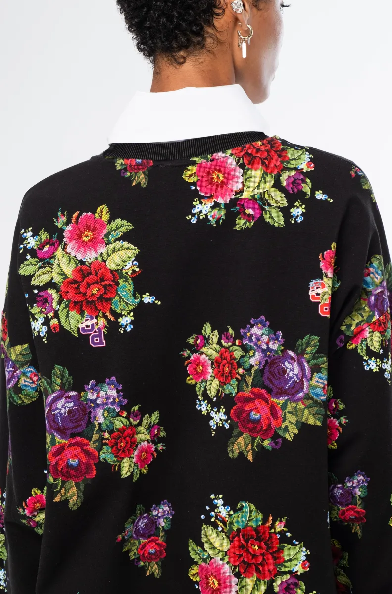 Το Bouquet Sweater συνδυάζει τη relaxed αισθητική ενός sweatshirt με θηλυκές, ιδιαίτερες λεπτομέρειες. Οι διακριτικές bishop sleeves και το εντυπωσιακό all-over print με ψηφιακά σχεδιασμένα λουλούδια εμπνευσμένα από την τεχνική του cross stitch χαρίζουν στο κομμάτι ξεχωριστό χαρακτήρα.