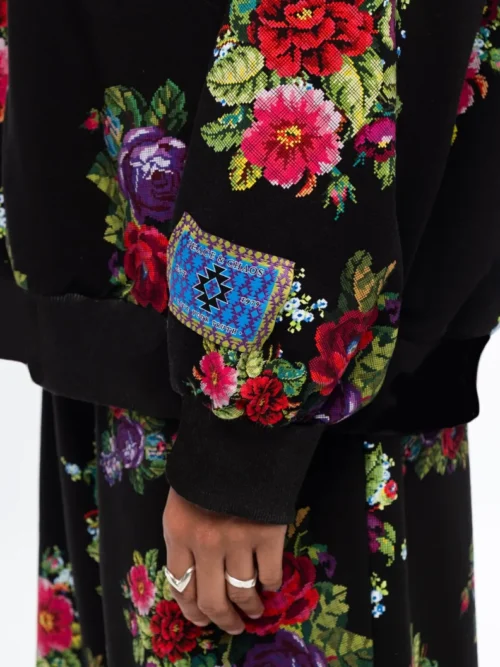 Το Bouquet Sweater συνδυάζει τη relaxed αισθητική ενός sweatshirt με θηλυκές, ιδιαίτερες λεπτομέρειες. Οι διακριτικές bishop sleeves και το εντυπωσιακό all-over print με ψηφιακά σχεδιασμένα λουλούδια εμπνευσμένα από την τεχνική του cross stitch χαρίζουν στο κομμάτι ξεχωριστό χαρακτήρα.