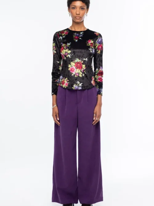 Το Bouquet Top ξεχωρίζει για το εντυπωσιακό all-over floral print με ψηφιακά λουλούδια εμπνευσμένα από την τεχνική του cross stitch, πάνω σε μαύρο ice velvet με ιδιαίτερη ανάγλυφη υφή.