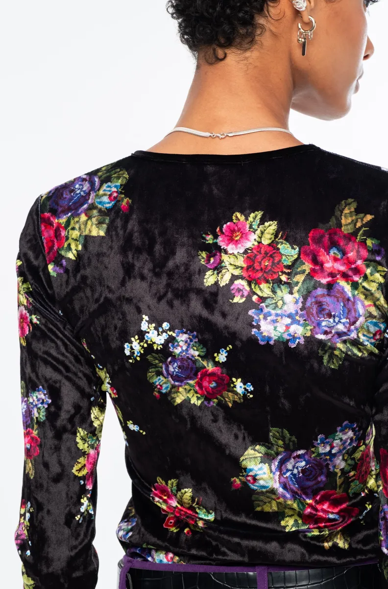Το Bouquet Top ξεχωρίζει για το εντυπωσιακό all-over floral print με ψηφιακά λουλούδια εμπνευσμένα από την τεχνική του cross stitch, πάνω σε μαύρο ice velvet με ιδιαίτερη ανάγλυφη υφή.