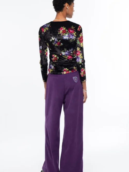 Το Bouquet Top ξεχωρίζει για το εντυπωσιακό all-over floral print με ψηφιακά λουλούδια εμπνευσμένα από την τεχνική του cross stitch, πάνω σε μαύρο ice velvet με ιδιαίτερη ανάγλυφη υφή.