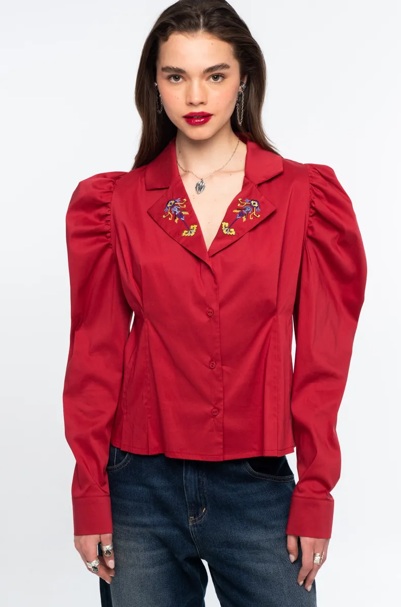 w26218_2_1 Το Emblem Shirt της Peace + Chaos είναι ένα ιδιαίτερο πουκάμισο από βαμβακερή ποπλίνα, που ξεχωρίζει για τα ρομαντικά gigot μανίκια και την εντυπωσιακή κεντημένη λεπτομέρεια με floral μοτίβο στον γιακά. Η κομψή του γραμμή συνδυάζει τη σύγχρονη αισθητική με την ξεχωριστή σχεδιαστική ταυτότητα των Ελλήνων designers της Peace + Chaos.