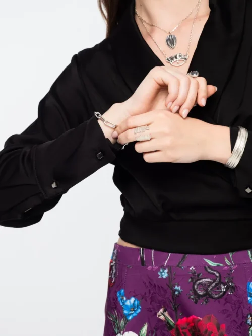 Το Moss Top της Peace + Chaos είναι μια κομψή wrap μπλούζα από πολυτελή satin viscose, σχεδιασμένη για να αναδεικνύει τη γυναικεία σιλουέτα. Διαθέτει απαλό shawl collar και δέσιμο στη μέση, προσφέροντας ρυθμιζόμενη εφαρμογή και elegant εμφάνιση.
