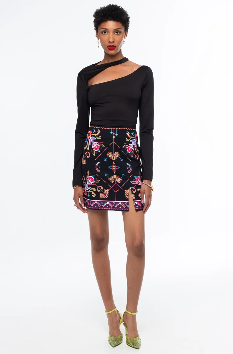 Η Emblem Mini Skirt της Peace + Chaos είναι μια εφαρμοστή mini φούστα με έντονες χρωματικές αντιθέσεις και ιδιαίτερο placement print, εμπνευσμένο από ψηφιακές αναπαραστάσεις παραδοσιακών κεντημάτων λαϊκής τέχνης.