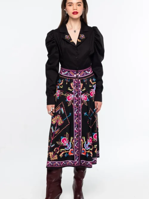 Η Emblem Midi Skirt της Peace + Chaos είναι μια εντυπωσιακή midi φούστα σε A-line γραμμή, με ιδιαίτερο placement print εμπνευσμένο από ψηφιακές αναπαραστάσεις παραδοσιακών μοτίβων λαϊκής τέχνης, διακοσμητικών borders και κεντημάτων.