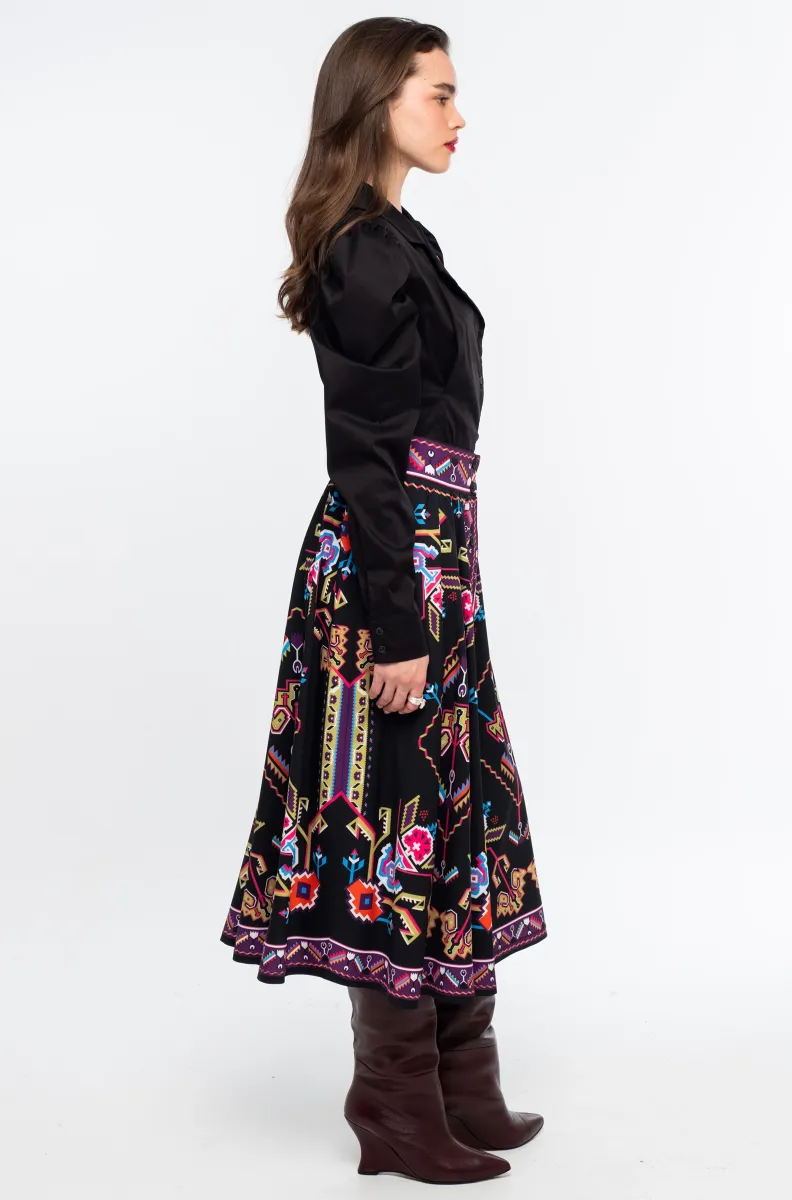 Η Emblem Midi Skirt της Peace + Chaos είναι μια εντυπωσιακή midi φούστα σε A-line γραμμή, με ιδιαίτερο placement print εμπνευσμένο από ψηφιακές αναπαραστάσεις παραδοσιακών μοτίβων λαϊκής τέχνης, διακοσμητικών borders και κεντημάτων.