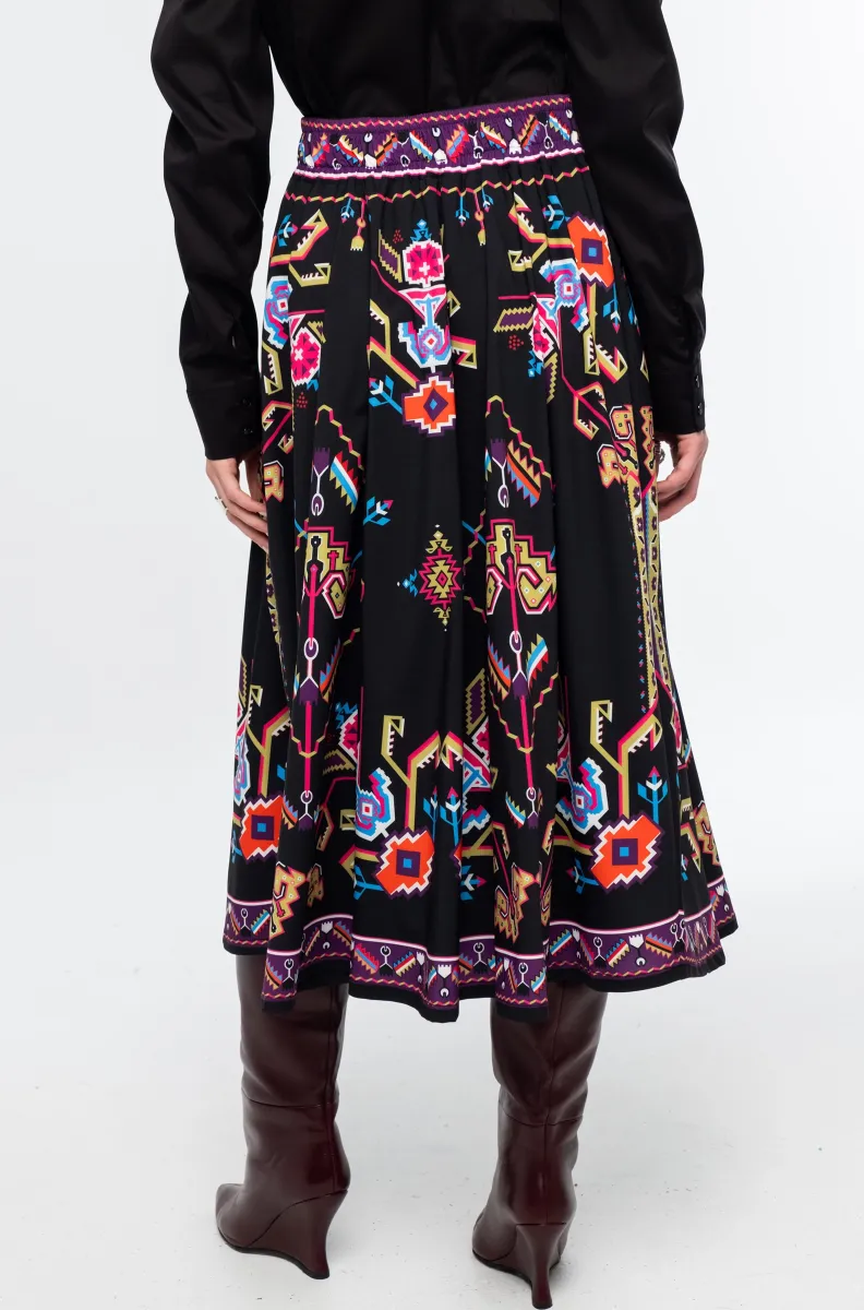 Η Emblem Midi Skirt της Peace + Chaos είναι μια εντυπωσιακή midi φούστα σε A-line γραμμή, με ιδιαίτερο placement print εμπνευσμένο από ψηφιακές αναπαραστάσεις παραδοσιακών μοτίβων λαϊκής τέχνης, διακοσμητικών borders και κεντημάτων.