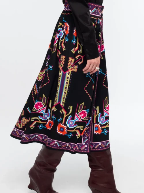 Η Emblem Midi Skirt της Peace + Chaos είναι μια εντυπωσιακή midi φούστα σε A-line γραμμή, με ιδιαίτερο placement print εμπνευσμένο από ψηφιακές αναπαραστάσεις παραδοσιακών μοτίβων λαϊκής τέχνης, διακοσμητικών borders και κεντημάτων.