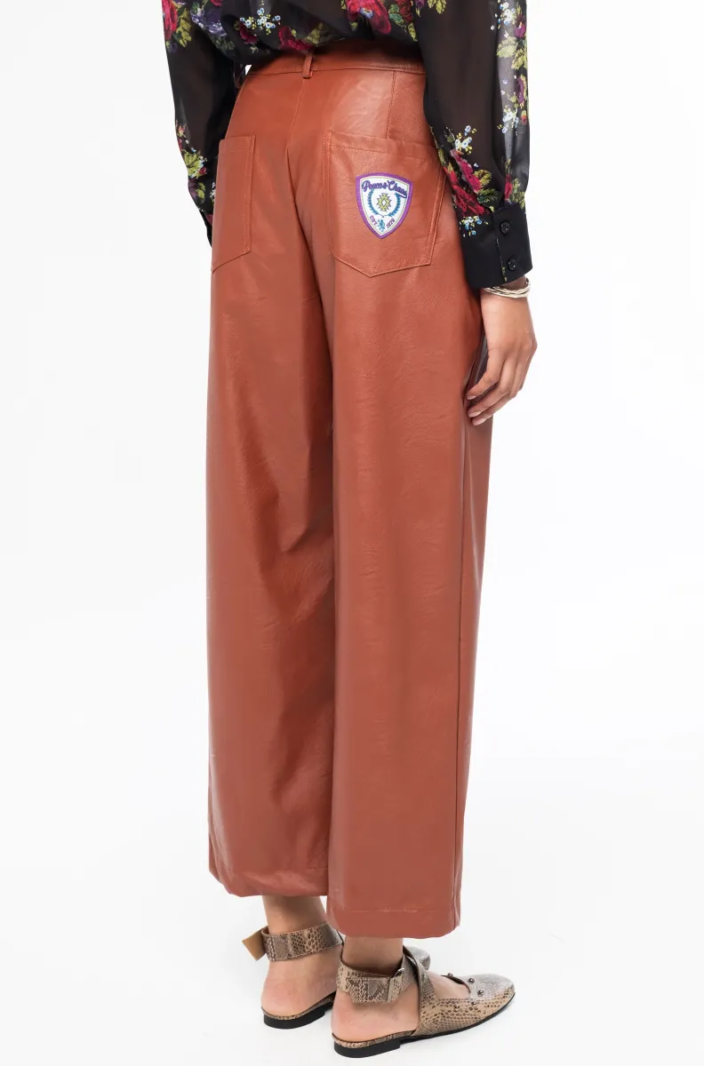 Το Honey Pants της Peace + Chaos είναι ένα μοντέρνο παντελόνι από eco-leather, σχεδιασμένο σε ίσια γραμμή για κομψές και σύγχρονες εμφανίσεις. Διαθέτει ψηλόμεση εφαρμογή και cropped μήκος, δημιουργώντας μια ιδιαίτερη σιλουέτα που μπορεί να συνδυαστεί εύκολα με διαφορετικά styles.