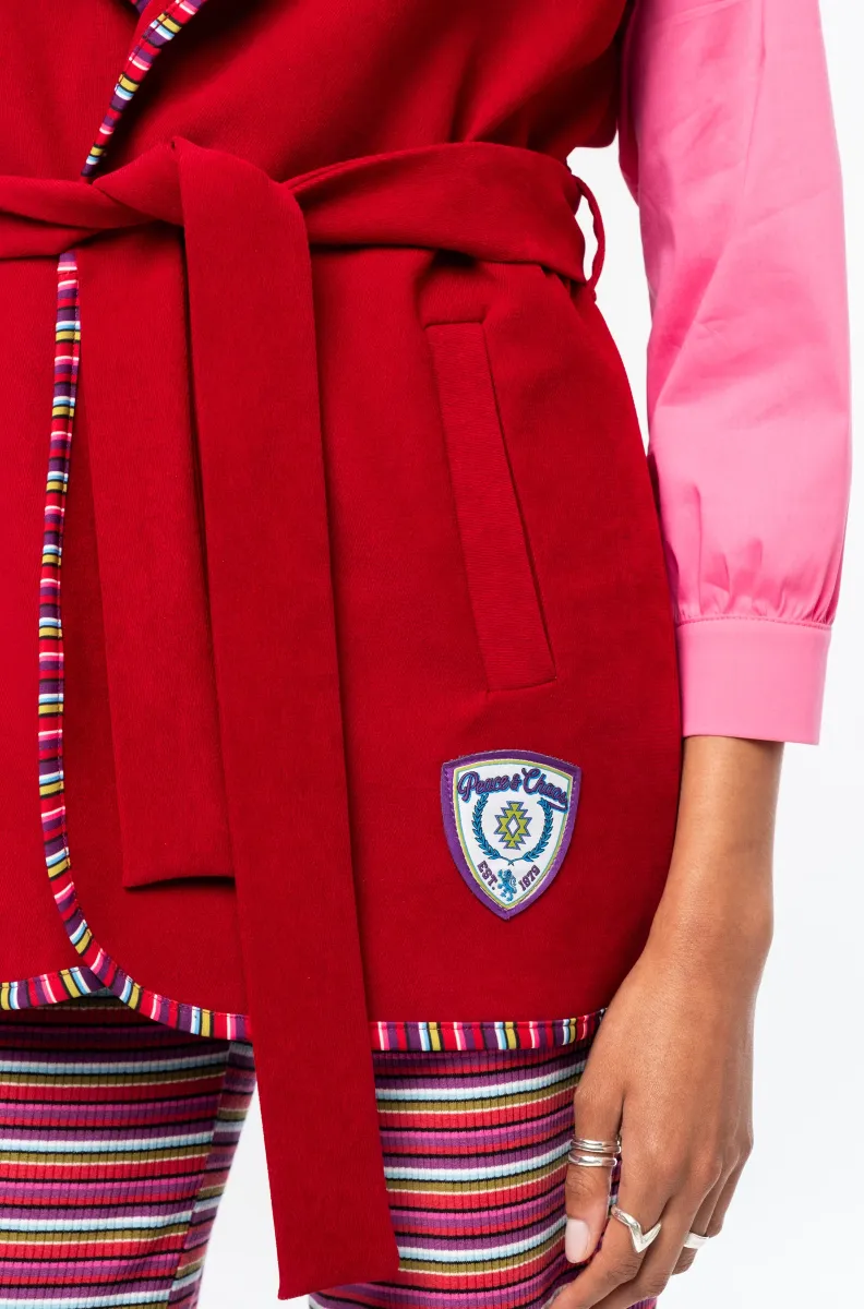 Το Campus Waistcoat της Peace + Chaos είναι ένα ιδιαίτερο αμάνικο γιλέκο που συνδυάζει bordeaux baby corduroy με πολύχρωμες ριγέ λεπτομέρειες σε all-over print. Η φόδρα και τα printed trims δημιουργούν μια ξεχωριστή αντίθεση, προσδίδοντας στο κομμάτι σύγχρονο και ιδιαίτερο χαρακτήρα.