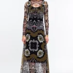 Το BLOOM LONG DRESS της Peace + Chaos ξεχωρίζει με μια ιδιαίτερη χρωματική παλέτα σε olive, μαύρο και λευκό, με έντονες κόκκινες πινελιές. Το εντυπωσιακό placement print σε smooth stretch mesh συνδυάζει λεπτομέρειες εμπνευσμένες από την Art Nouveau αισθητική με floral μοτίβα και συμβολισμούς που παραπέμπουν στην αγάπη και την προστασία.