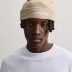 Ο σκούφος Kingdom Logo Beanie της PEGADOR σε μπεζ χρώμα συνδυάζει τη minimal αισθητική με το σύγχρονο streetwear στιλ.