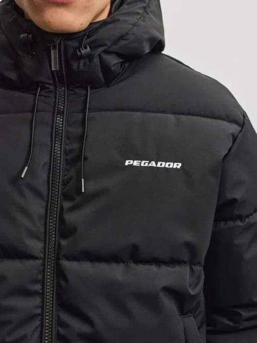 Το Pegador Bertinoro Hooded Puffer Jacket συνδυάζει μοντέρνα streetwear αισθητική με πρακτικό σχεδιασμό για τις κρύες ημέρες. Η oversized γραμμή προσφέρει άνετη εφαρμογή, ενώ οι χαμηλωμένοι ώμοι δημιουργούν relaxed look.