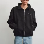 Το Alto Teddy Jacket της PEGADOR σε μαύρο χρώμα συνδυάζει τη μοντέρνα streetwear αισθητική με την άνεση και τη ζεστασιά.