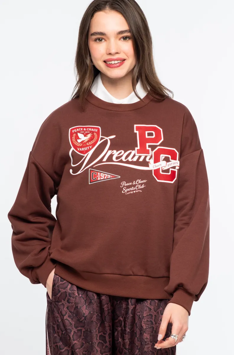 Το Varsity Sweater της Peace + Chaos συνδυάζει τη διαχρονική αισθητική των αμερικανικών κολεγίων με τη σύγχρονη δημιουργική ταυτότητα του brand. Κατασκευασμένο