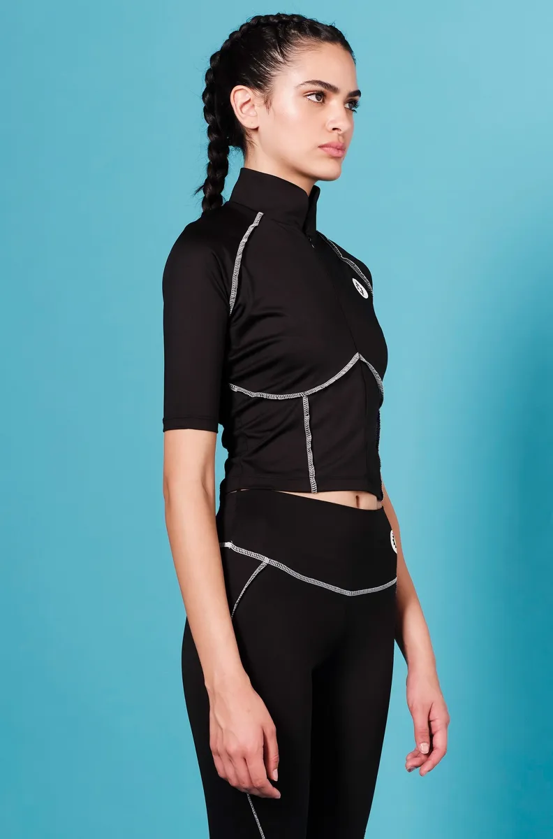 Το Stillness Top της Peace + Chaos συνδυάζει sporty αισθητική, άνεση και ξεχωριστές σχεδιαστικές λεπτομέρειες. Σε μαύρο χρώμα, διαθέτει ραφές σε contrasting απόχρωση που αναδεικνύουν τις καμπύλες και το περίγραμμα του σώματος, ενώ το χαρακτηριστικό Chaka logo σε βινύλιο λειτουργεί ως ιδιαίτερη σχεδιαστική πινελιά.