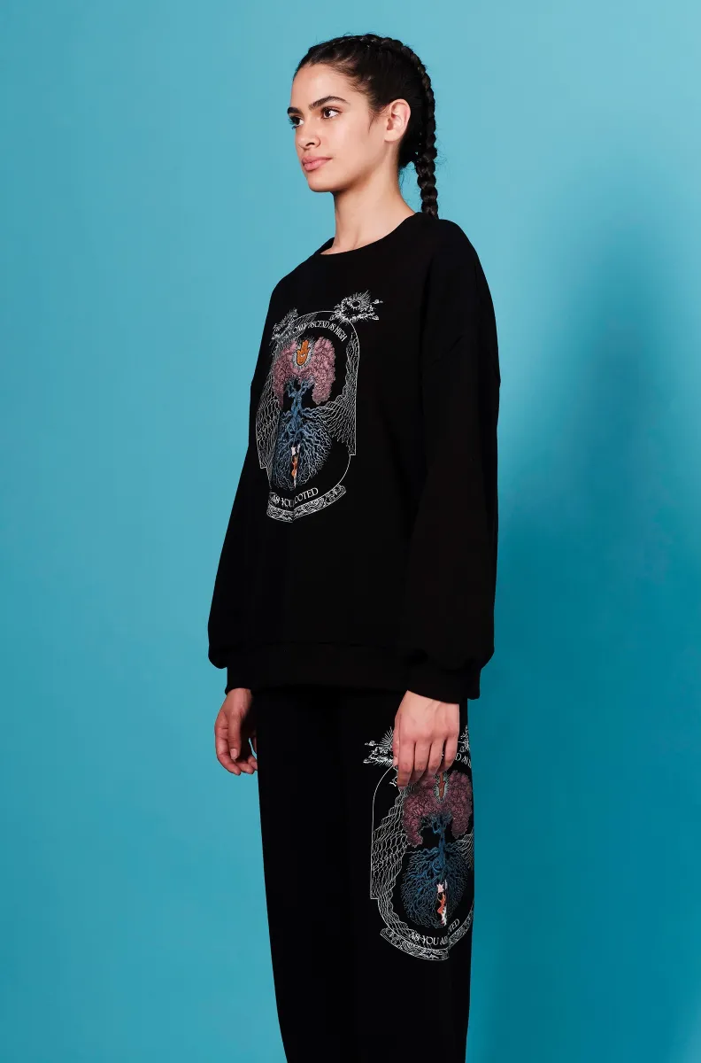Το Anavasis Jumper της Peace + Chaos συνδυάζει άνεση, διαχρονικό design και ένα ιδιαίτερο μήνυμα. Σε μαύρη απόχρωση, το sweatshirt διαθέτει ένα εντυπωσιακό screen print με το Δέντρο της Ζωής, μαζί με το εμπνευσμένο μήνυμα «You can only ascend as highly as you are rooted».
