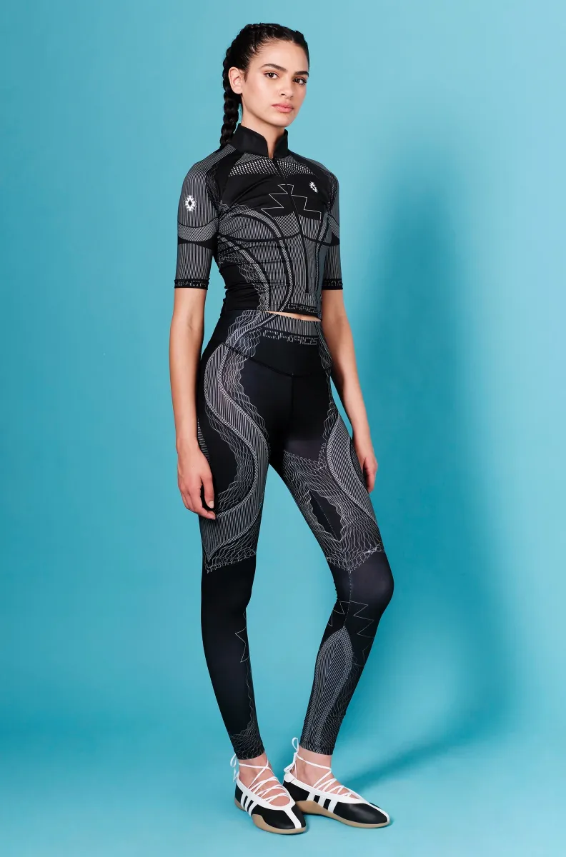 Τα Flux Leggings της Peace + Chaos συνδυάζουν άνεση, ελαστικότητα και ένα ξεχωριστό statement design. Το ιδιαίτερο placement print, εμπνευσμένο από τη ροή των ηχητικών κυμάτων, δημιουργεί ένα δυναμικό αποτέλεσμα που ακολουθεί την αισθητική της κίνησης.